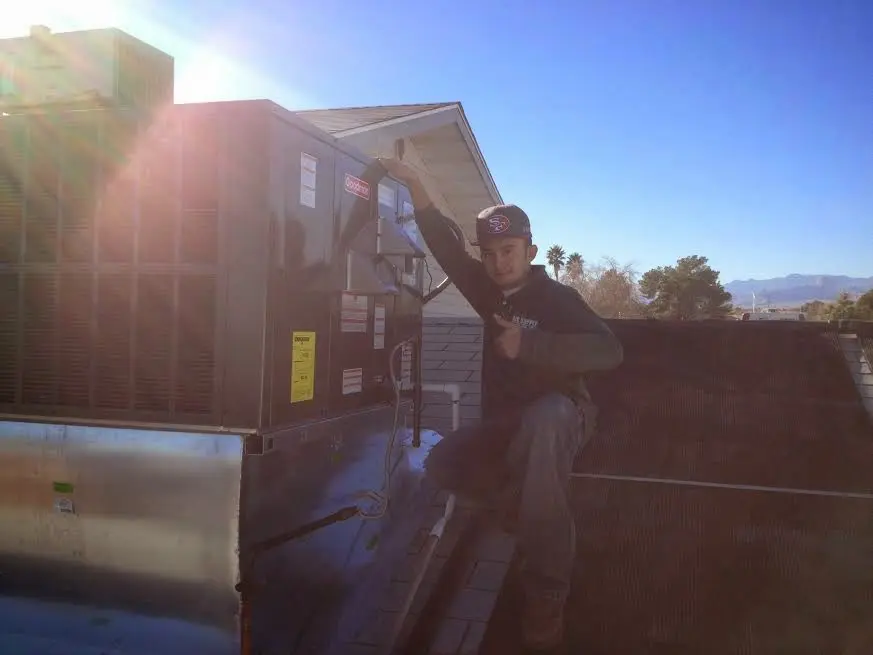 HVAC technician performing Boiler Repair on a rooftop unit in Riverside